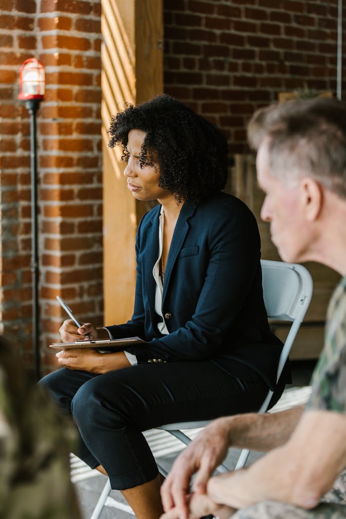 Therapist supports military veteran in a counseling session, fostering communication and healing.